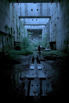 a man is walking through an abandoned building with puddles in the floor and walls