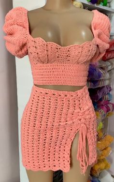 a mannequin wearing a pink crochet top and skirt