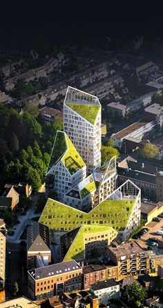 an aerial view of some buildings with green roofing on the top and bottom floors