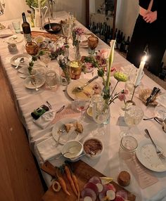 a table is set with food and candles for a dinner party or special occasion to be served