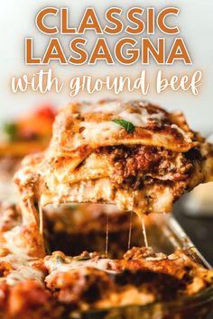 lasagna with ground beef is being lifted from the casserole dish and topped with parmesan cheese