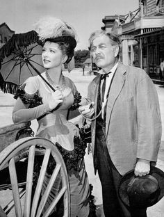 an old black and white photo of a man and woman standing next to each other