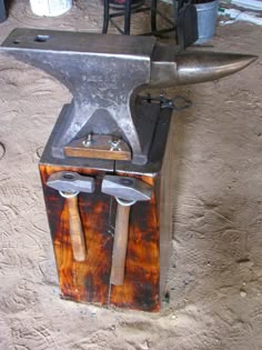 an old style blacksmith block with two large hammers on it's back end