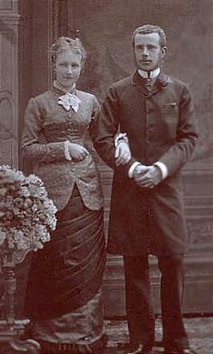 an old black and white photo of a man and woman standing next to each other