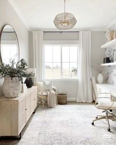 a living room with white furniture and a chandelier hanging from the light fixture