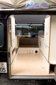 the interior of an rv with its door open and storage area in place on the side