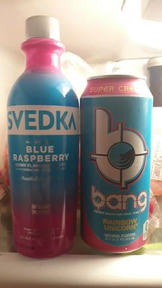 two soda cans sitting on top of a refrigerator