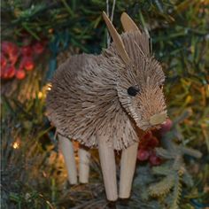 an ornament made out of wood sticks is hanging on a christmas tree branch