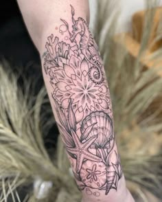 a woman's arm with a tattoo on it and flowers in the middle of her arm