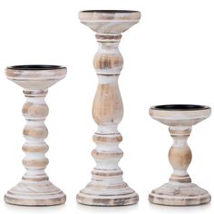 three white wooden candlesticks on a white background