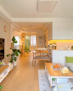 a living room filled with furniture and a flat screen tv on top of a wooden table