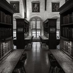 an old library with many bookshelves and desks in black and white photo