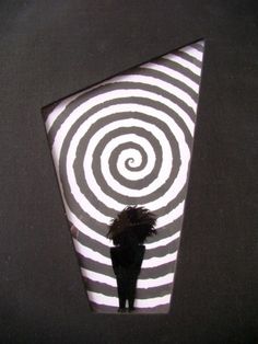 a person standing in front of a black and white striped object with spiral design on it