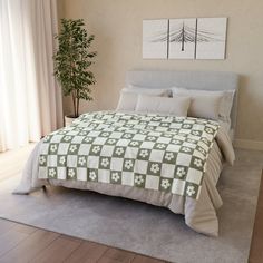 a bedroom with a large bed covered in green and white quilted bedspread