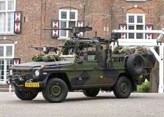 an army vehicle parked in front of a brick building