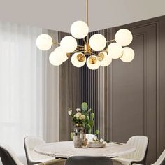 a dining room table with chairs and a chandelier hanging from the ceiling over it