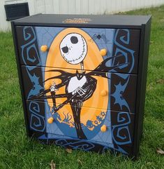 a painted dresser in the grass with a jack skellingy figure on it's side