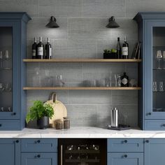 a kitchen with blue cabinets and shelves filled with wine glasses, bottles and utensils