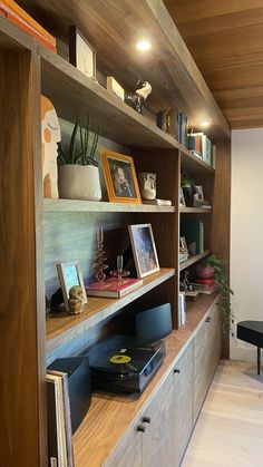 the bookshelf is filled with various items and pictures, including an old record player