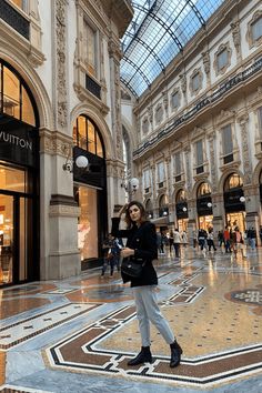 a woman standing in the middle of a shopping mall