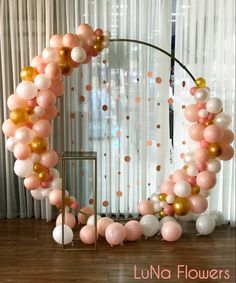 the balloon arch is decorated with pink, gold and white balloons