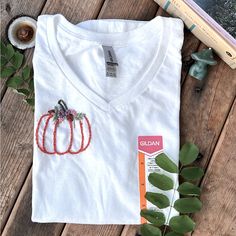 I Embroidered This Little Pumpkin To Be Worn Comfortably In The Fall! :) It’s A Super Cute And A Simple Design. I Love Anything Pumpkin Themed. Message Me For Any Questions. Thank You! Cotton V-neck T-shirt With Floral Embroidery, V-neck Cotton T-shirt With Floral Embroidery, Floral Embroidered Cotton V-neck T-shirt, Fall Cotton T-shirt With Floral Embroidery, Custom Embroidered White T-shirt For Fall, White T-shirt With Custom Embroidery For Fall, White Custom Embroidered T-shirt For Fall, Embroidered White T-shirt For Fall, Custom Embroidery Short Sleeve T-shirt