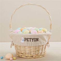 a basket filled with eggs sitting on top of a table next to some candies