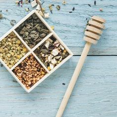 a wooden spoon with various spices in it next to a bowl filled with nuts and seeds