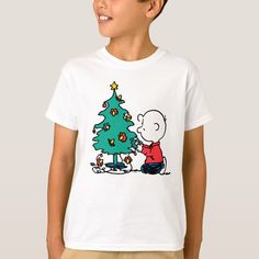 a young boy wearing a charlie brown christmas tree t - shirt