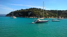 several sailboats are anchored in the blue water