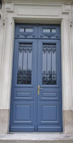 two blue doors with wrought iron bars on them