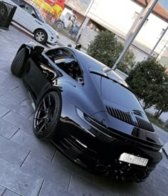 a black sports car is parked on the street