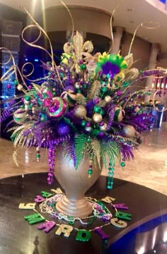 a vase filled with lots of purple and green decorations on top of a table in a room