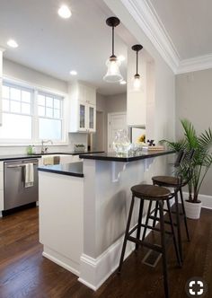 a kitchen with two stools next to an island