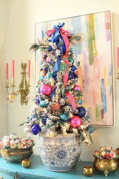 a decorated christmas tree sitting on top of a blue table