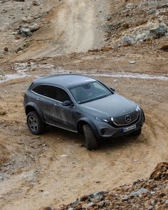 a grey suv driving down a dirt road