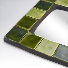 a mirror that has some green tiles on it