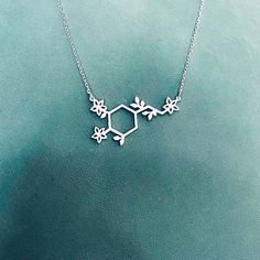 "Sterling Silver Dopamine Necklace with tiny leaves and flowers. Dopamine Molecule represents the passion and the devotion in our lives. This necklace is a great way to let others know how happy they make you! ✅ PRODUCT DETAILS * Material: solid sterling silver. * Pendant is 1.3mm thick. * The total length is the chain length only, it does not include the length of the charm. * All necklaces come with a 2\" extender for adjustable length. ✅ PRODUCTION & SHIPPING INFO 📌 Important: please be Dopamine Jewelry, Dopamine Necklace, Science Necklace, Molecule Jewelry, Science Christmas, Chemistry Necklace, Dopamine Molecule, Chemistry Jewelry, Molecule Necklace