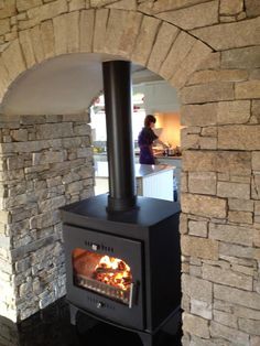 a wood burning stove sitting inside of a kitchen