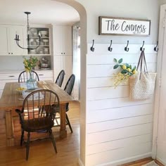 a dining room table and chairs in front of a wall with the words the corners on it