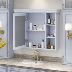 a bathroom with blue cabinets and gold faucet