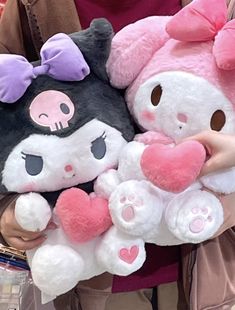 two stuffed animals are being held by someone