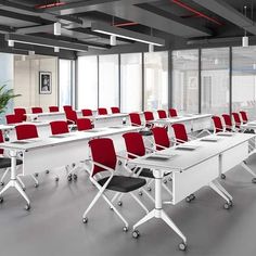 an empty conference room with red chairs and white tables