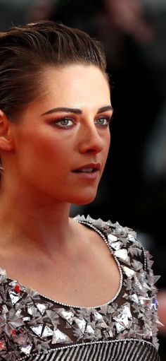 a close up of a person wearing a dress and looking off to the side with eyes wide open