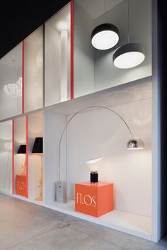 a store front with two lamps hanging from it's ceiling and an orange box on the floor