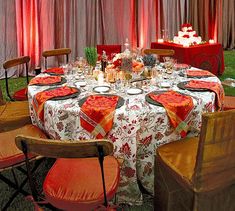 the table is set with red and orange linens