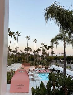 an outdoor swimming pool surrounded by palm trees