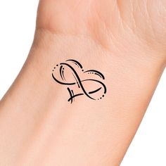 a small tattoo on the wrist of a woman's arm with an initial letter