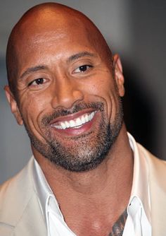 a bald man with a goatee smiles at the camera