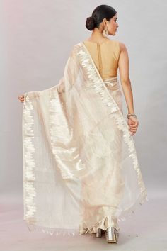 The charm of this cream tissue Banarasi sari is sure to leave everyone awestruck! It is enhanced with zari work and comes with a matching blouse piece. Disclaimer: The shown stitched blouse on the model is for display purpose only. The saree comes with a matching blouse piece and finished with fall and piko. Banarasi Sari, Tussar Silk Sarees, Indian Clothing Store, Latest Designer Sarees, Fashion Journals, Tussar Silk Saree, Banarasi Saree, Zari Work, Indian Clothing